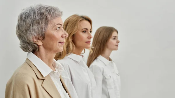 Fila de três gerações femininas caucasianas graves — Fotografia de Stock