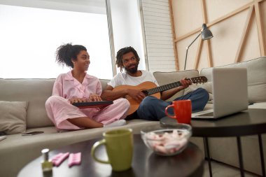 Erkek ve kız evde müzik enstrümanları çalıyor.