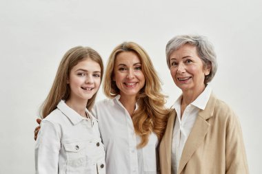 Gülümseyen beyaz bir aile. Üç kadın sarılıyor.