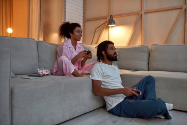 Siyah çift evdeki joysticklerle oyun oynuyor.