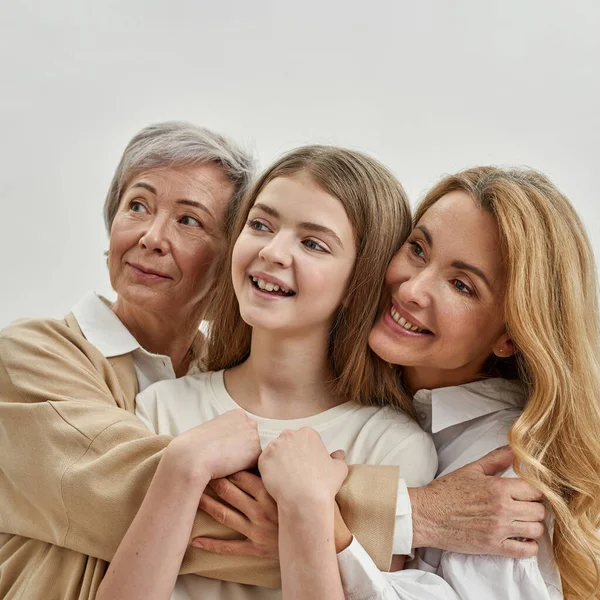 Nonna, mamma e nipotina abbracciano e distolgono lo sguardo — Foto Stock