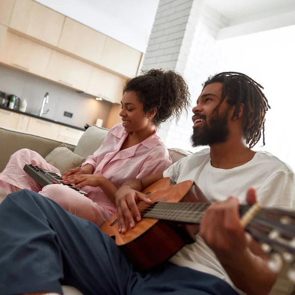 Nero coppia giocare musica insieme su divano a casa — Foto Stock