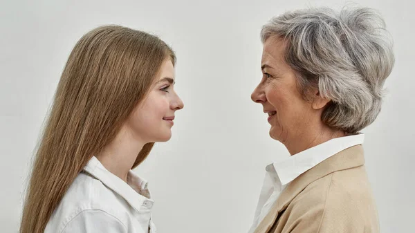 Улыбающаяся девушка и бабушка смотрят друг на друга — стоковое фото