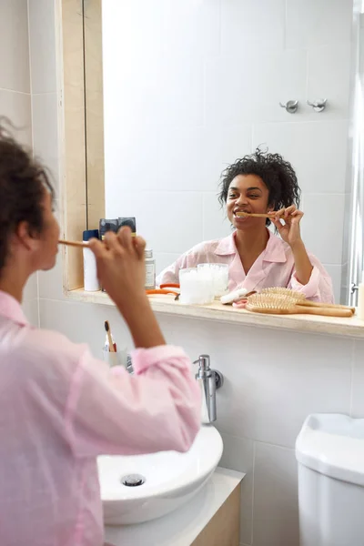 Joven mujer negra cepillándose los dientes en el baño — Foto de Stock