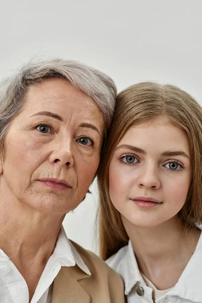 Ernstes Mädchen und Großmutter Kopf an Kopf — Stockfoto