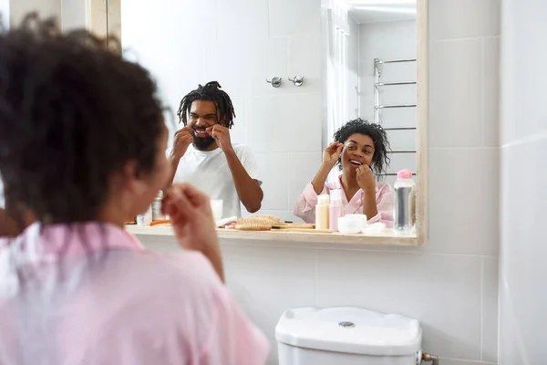 Pareja negra cepillándose los dientes con hilo dental — Foto de Stock