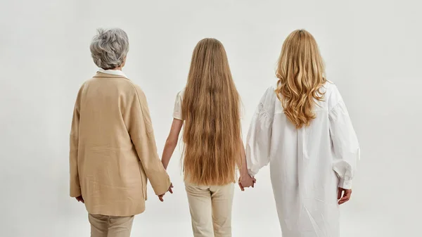 Bakåt bild av familj av tre kvinnor som håller händer — Stockfoto