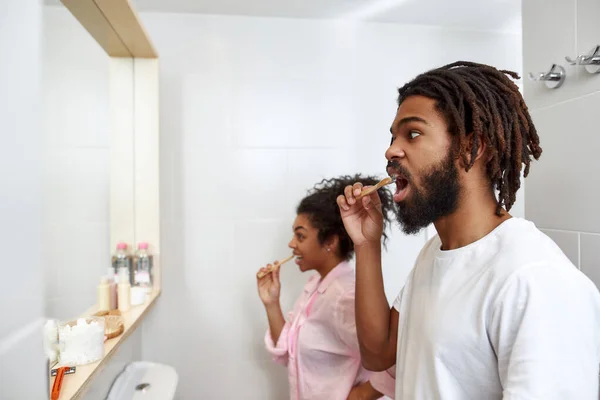 Pareja cepillarse los dientes con cepillos de dientes en el baño — Foto de Stock