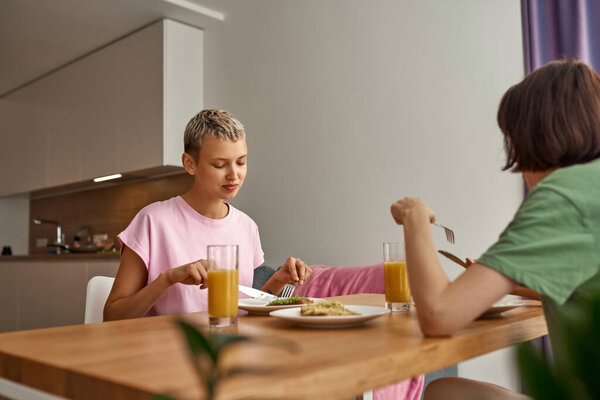 Молодые девушки завтракают дома за столом