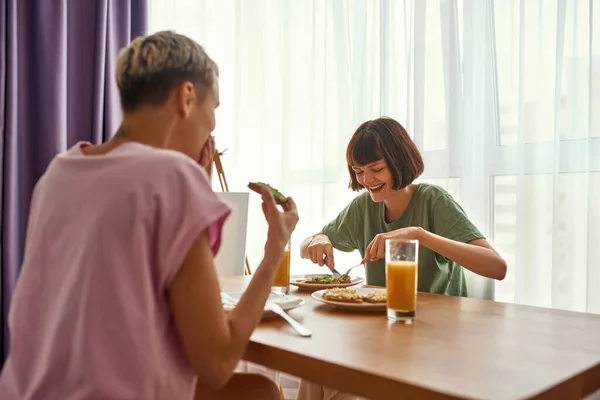 Lesbian couple having breakfast at table at home — Stock Photo, Image