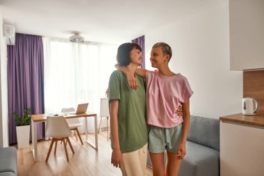 Lezbiyen çift sarılıp birbirlerine bakıyorlar.