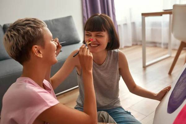 Jovens lésbicas meninas tocar narizes com pincéis — Fotografia de Stock