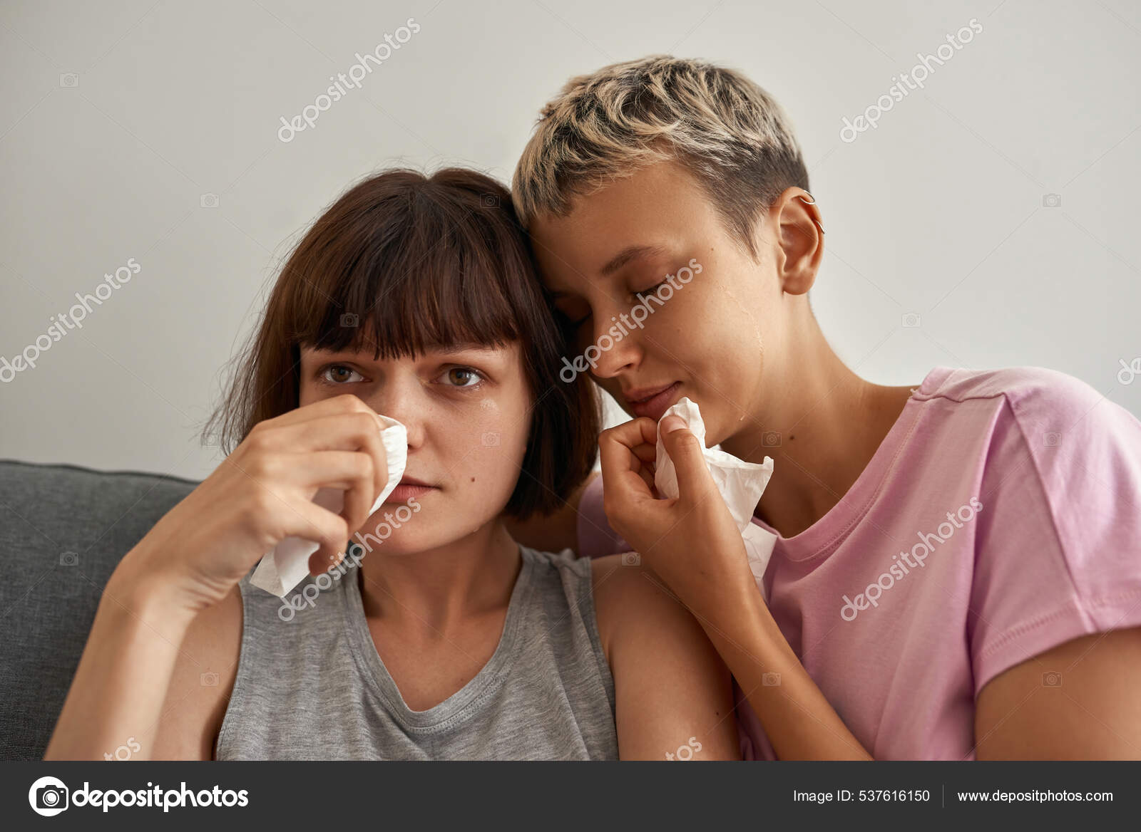Юные грустные лесбиянки смотрят телевизор и плачут стоковое фото ©LanaStock 537616150
