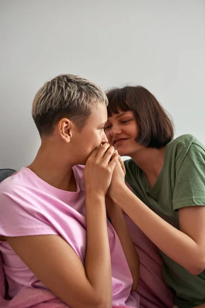 Unga lesbiska tjejer håller hand på soffan hemma — Stockfoto