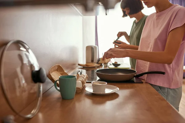 Young girls cooking breakfast at home kitchen — Stock Photo, Image