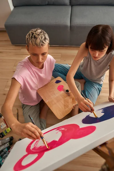 Concentrated lesbian girls paint picture at home — Foto Stock