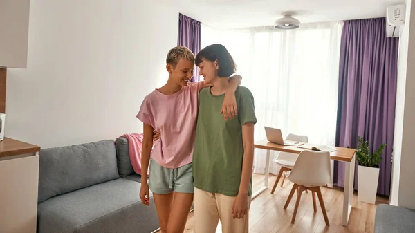 Young pleased lesbian girls hugging at home — Fotografia de Stock