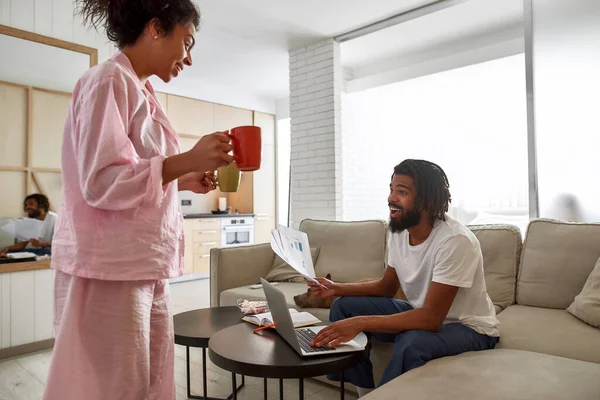 Woman brought cup with tea to boy who working — Foto Stock