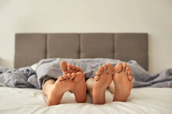 Voeten van lesbische meisjes onder deken op bed — Stockfoto