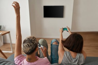 Lezbiyen kızların arka plandaki koltukta oyun oynamaları