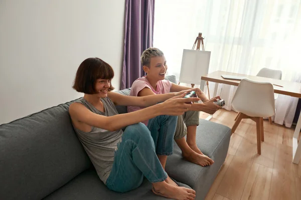 Young cheerful lesbian girls playing video game — Stock Fotó