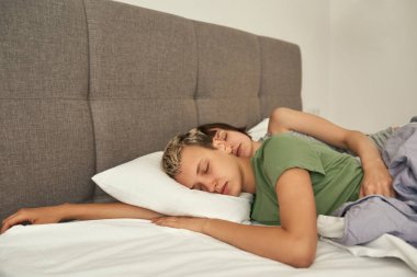 Genç beyaz lezbiyen çift yatakta uyuyor.