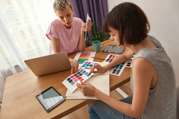 Mladé návrhářky dívají na barevnou paletu — Stock fotografie