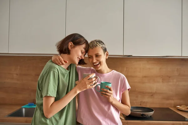 Pareja de lesbianas tomando té en la cocina por la mañana —  Fotos de Stock