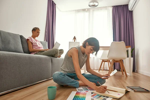 Designer working while her girlfriend use laptop — Stock Photo, Image