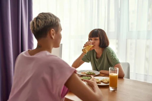 Young lesbians having breakfast at table at home — Foto Stock