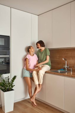 Lezbiyen kızlar ev mutfağında eğleniyor.