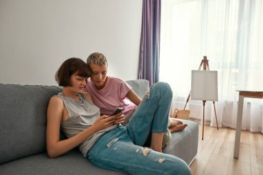 Akıllı telefondan izleyen genç odaklı lezbiyen kızlar.