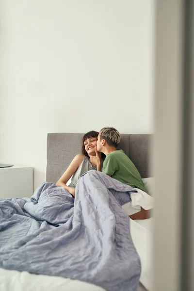 Chica besando novia en la cama en casa por la mañana — Foto de Stock