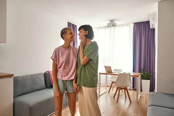 Lesbian couple hold hands and look at each other — Fotografia de Stock