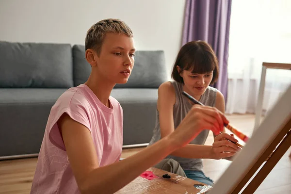 Joven lesbianas niñas pintura imagen en caballete — Foto de Stock