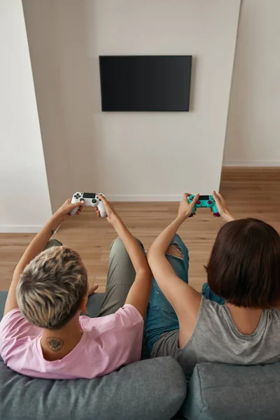 Back of lesbians playing video game with joysticks — Fotografia de Stock