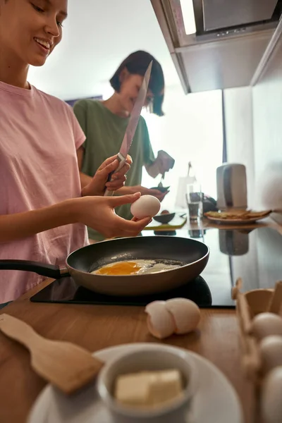 Young girls cooking breakfast at home kitchen — Stockfoto