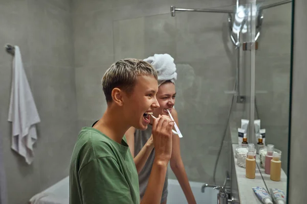 Side view of lesbians brushing teeth at morning — Fotografia de Stock