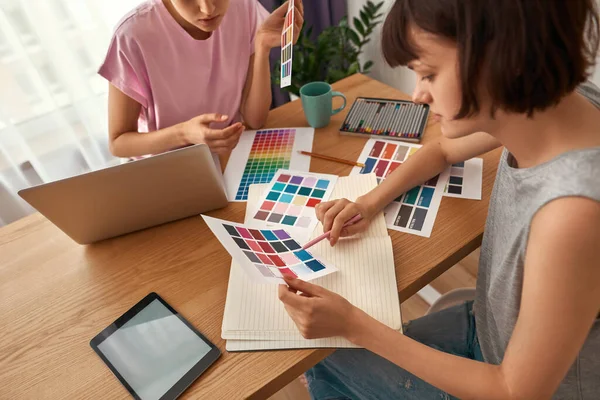 Jovens designers do sexo feminino escolhendo cor na paleta — Fotografia de Stock