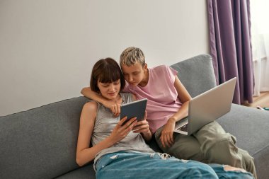 Dijital tablette kanepe üzerinde izleyen genç lezbiyenler