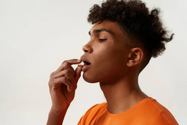 Profile of black serious man taking medical pill — Fotografia de Stock