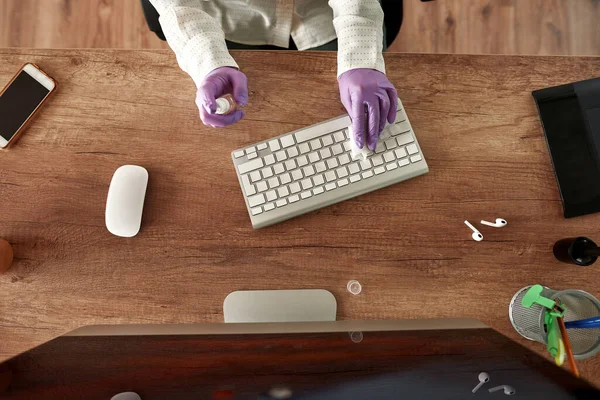 Recortado de niña que limpia el teclado de la computadora en el escritorio —  Fotos de Stock