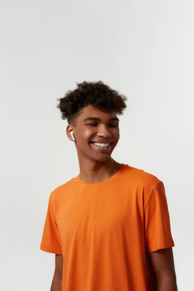 Smiling man listening music in wireless earphones — Stock Fotó
