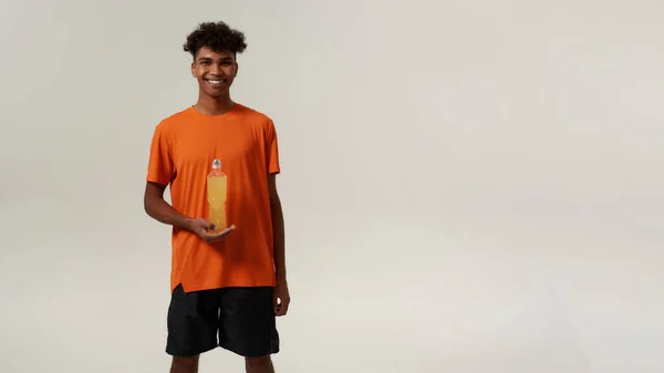 Black smiling man holding bottle with sport drink — Stock Photo, Image