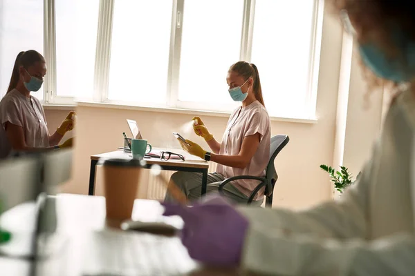 Young business woman apply sanitizer on smartphone — Stock Fotó