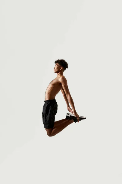 Zijaanzicht van jonge zwarte sportman springen — Stockfoto
