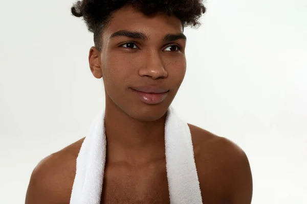 Black curly sportsman with towel looking away — Stock Photo, Image