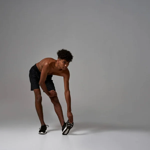 Preto homem de esportes alongamento e olhando para longe — Fotografia de Stock