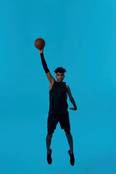 Black player jumping and throwing basketball ball — Stock Fotó