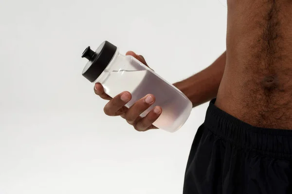 Partial of black sportsman hold bottle with water — Fotografia de Stock